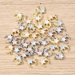 Detailed view of crescent moon and star charms with colorful inlay for DIY jewelry