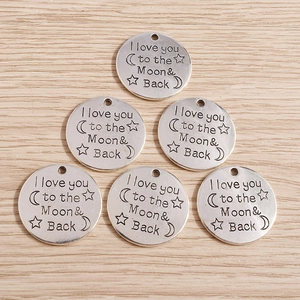 Macro detail of retro silver pendants engraved with I love you to the moon and back