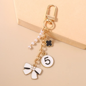 Detail of luxury keychain with white pearls, black clover, and number 5 pendant charm