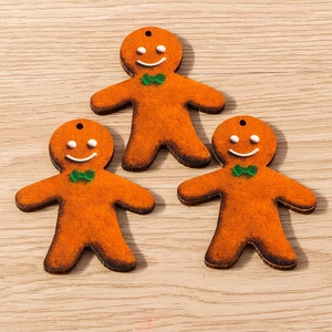 Three gingerbread man cartoon pendants with green bows for Christmas jewelry making