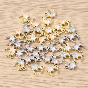 Macro detail of star and moon charms with iridescent resin in gold and silver metal frames