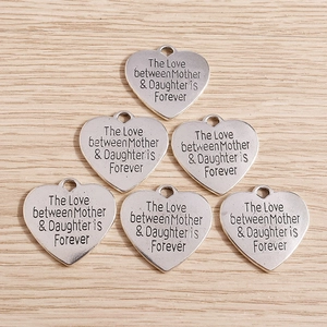 Close-up of heart-shaped alloy charms with mother daughter engraving for jewelry DIY
