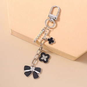 Detailed shot of bow and clover pendant keychain with pearls and rhinestones on orange stand