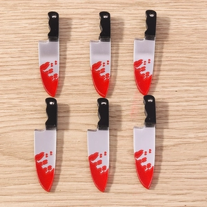 Macro detail of acrylic horror cleaver pendants with red blood splatter for Halloween DIY