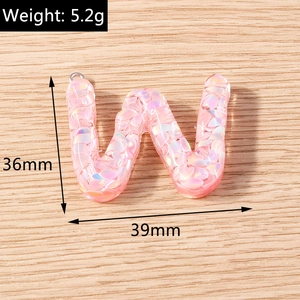 Macro detail of a 36mm pink glitter letter W pendant with 5.2g weight measurement