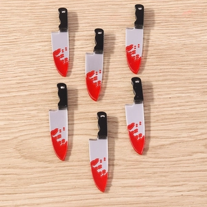 Macro shot of 6 acrylic bloody chef knife charms for Halloween DIY jewelry and crafts