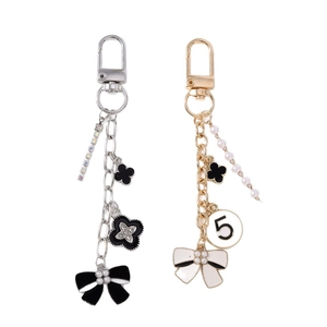 Elegant floral bow keychain with pearl tassels and clover charms in gold and silver finish