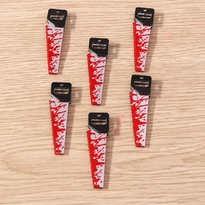 Macro detail of acrylic bloody chainsaw charms for Halloween DIY jewelry and crafts