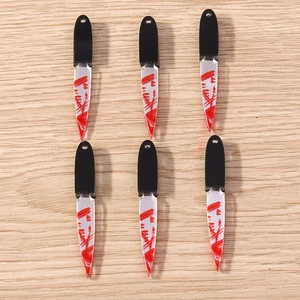 Detailed view of bloody acrylic knife charms for Halloween DIY jewelry making projects