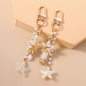 Detail of starfish charms with pearls and golden lobster clasp for keychains