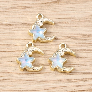 Macro shot of gold moon pendants with iridescent opal stars on a wooden surface