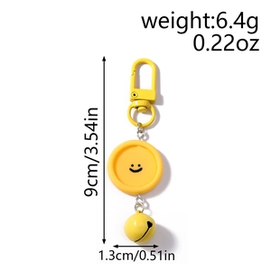 Détail du charme visage souriant jaune avec clochette et fermoir pour sacs