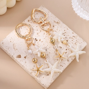 Detail of golden starfish pendants with imitation pearls and heart-shaped lobster clasps