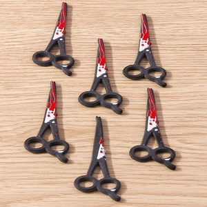 Macro detail of Halloween spooky bloody scissors charms for DIY jewelry making and crafts