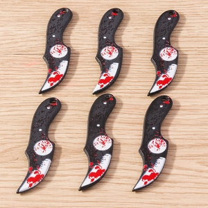 Macro view of six creative horror knife pendants with blood splatter effects for DIY jewelry