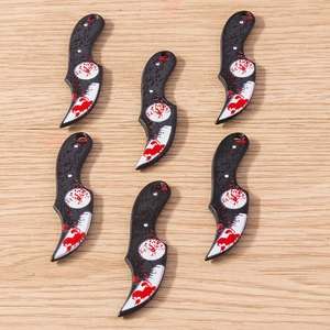 Macro shot of 6 blood-stained miniature Karambit pendants for Halloween DIY jewelry crafts