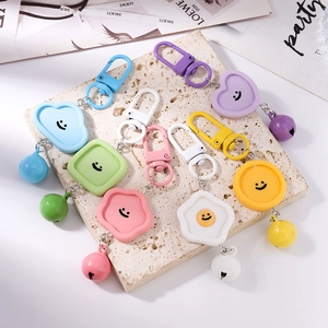 Détail macro de porte-clés souriants colorés style macaron avec petites cloches en métal