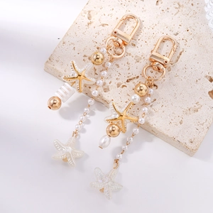 Detail of starfish charm keychain with elegant faux pearls and gold lobster clasp