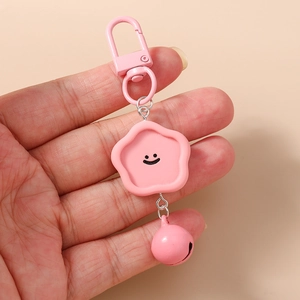 Porte-clés fleur rose avec pendentif visage souriant, fermoir mousqueton et petit grelot