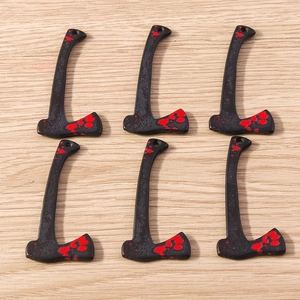 Macro detail of gothic style axe pendants with red splatter for Halloween DIY jewelry