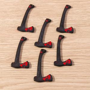 Close-up of black axe charms with red blood splatter for Halloween DIY jewelry making