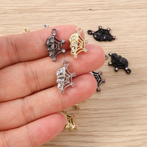Detailed view of skull and spider web charms with rhinestones for DIY jewelry