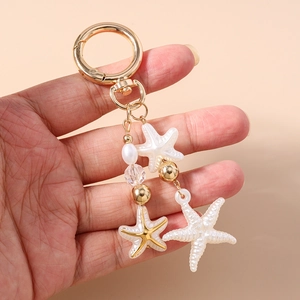 Detailed close-up of ocean theme keychain with white faux pearls and starfish charms