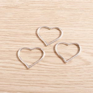 Tre ciondoli a cuore in filo d'argento per la creazione di gioielli fai da te su legno