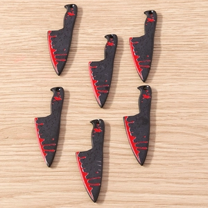 Detailed macro view of six bloody cleaver knife charms for Halloween DIY jewelry making