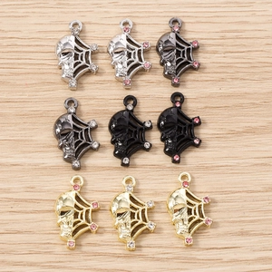Gothic skull and spider web charms set in silver, gold, and gunmetal for DIY jewelry