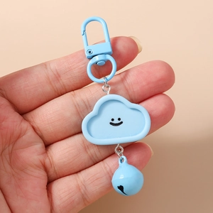 Porte-clés nuage bleu avec visage souriant et clochette assortie dans la main