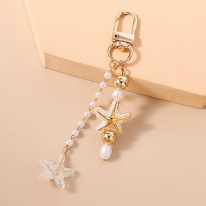 Detailed view of starfish keychain with pearls and gold starfish charms on display