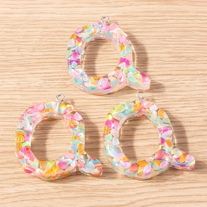 Close-up of letter Q macaron style pendant with colorful glitter for DIY crafts