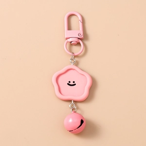 Gros plan du porte-clés fleur rose avec visage souriant et petit grelot assorti