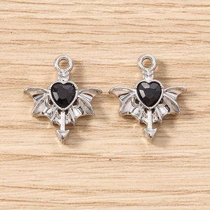 Macro shot of silver gothic bat wing pendants with black heart-shaped faceted gems