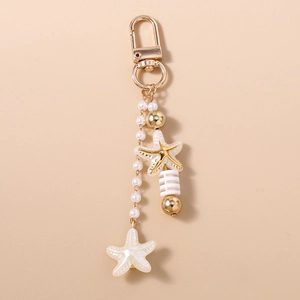 Detail of nautical keychain featuring starfish charms, white pearls and striped bead