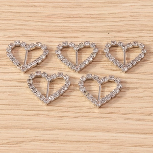 Five silver heart-shaped diamond rhinestone sliders for DIY jewelry on wooden surface