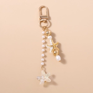 Detail of a starfish keychain featuring iridescent rainbow resin and white pearls on gold chain