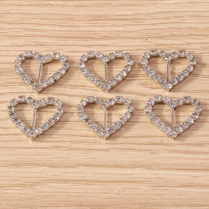 Detailed view of silver heart charms with sparkling rhinestones for DIY jewelry making