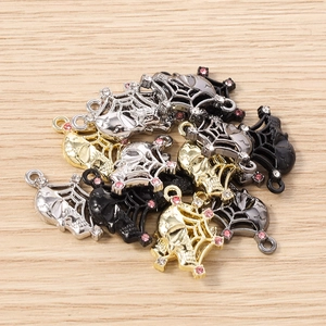 Macro detail of gothic skull and spider web alloy pendants with sparkling rhinestones