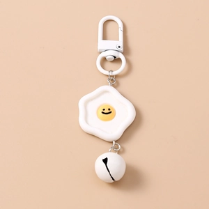 Détail du porte-clés œuf au plat avec mousqueton blanc, pendentif résine et clochette