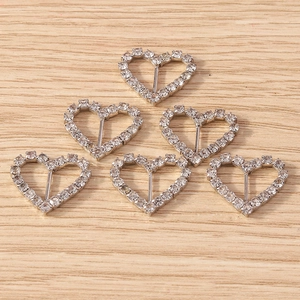 Close-up of heart-shaped silver buckles with inlaid rhinestones for DIY crafts
