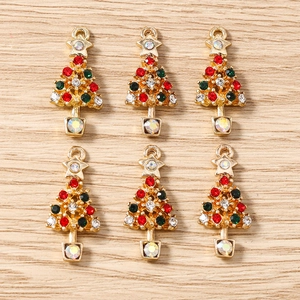 Détail de 6 pendentifs sapin de Noël dorés avec strass colorés sur fond bois