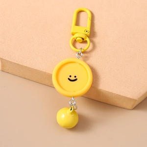 Détail du porte-clés visage souriant jaune avec fermoir mousqueton et breloque ronde