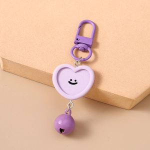 Vue détaillée d'un porte-clés coeur violet avec un smiley et un petit grelot assorti
