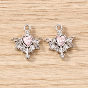 Macro detail of gothic bat wing heart charms with pink gemstone for DIY jewelry making