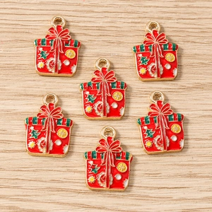 Détail de breloques en émail cadeau de Noël rouge avec nœud doré pour bijoux faits main