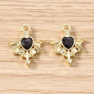 Detail of dark heart-shaped pendants with wings and arrows for DIY jewelry making