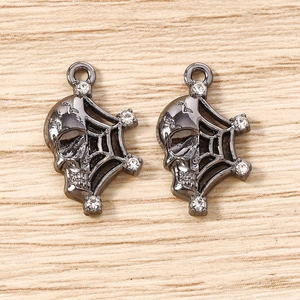 Macro detail of dark gothic skull and spider web charms with clear crystal accents