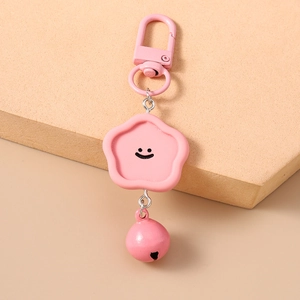 Porte-clés étoile rose avec un visage souriant et un petit grelot décoratif suspendu